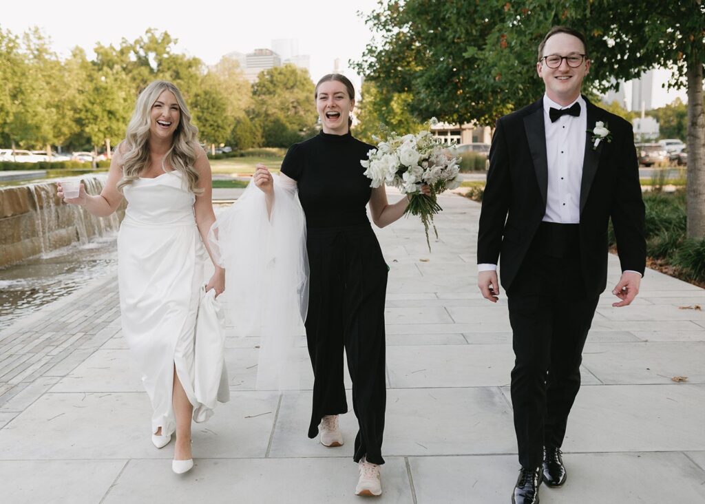 Wedding planner with bride and groom holding bride's veil