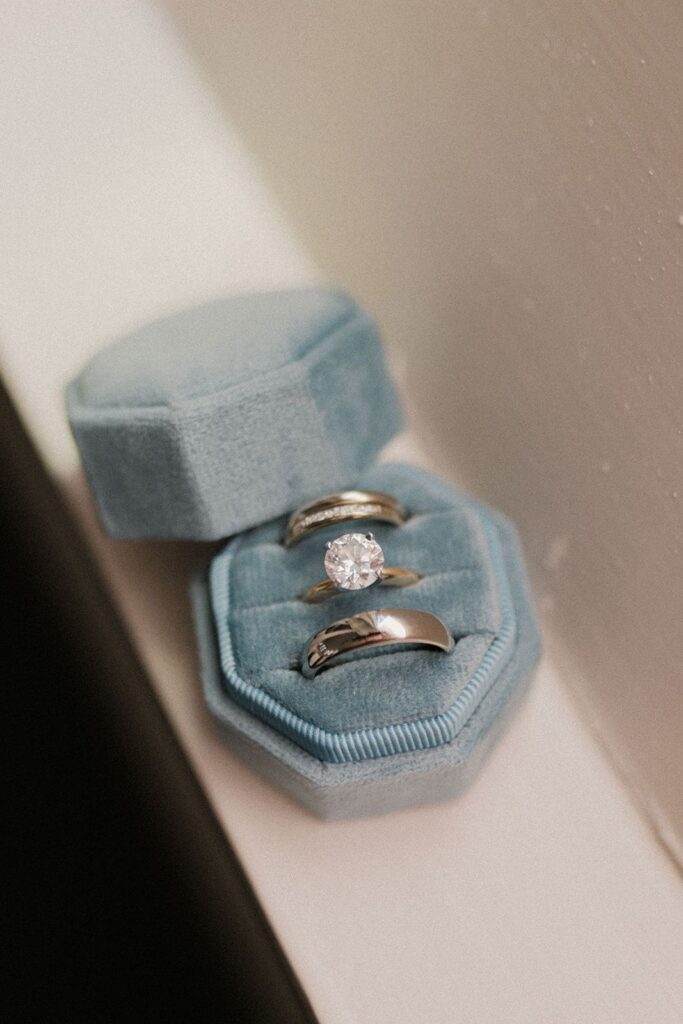 Engagement ring and wedding bands in blue box