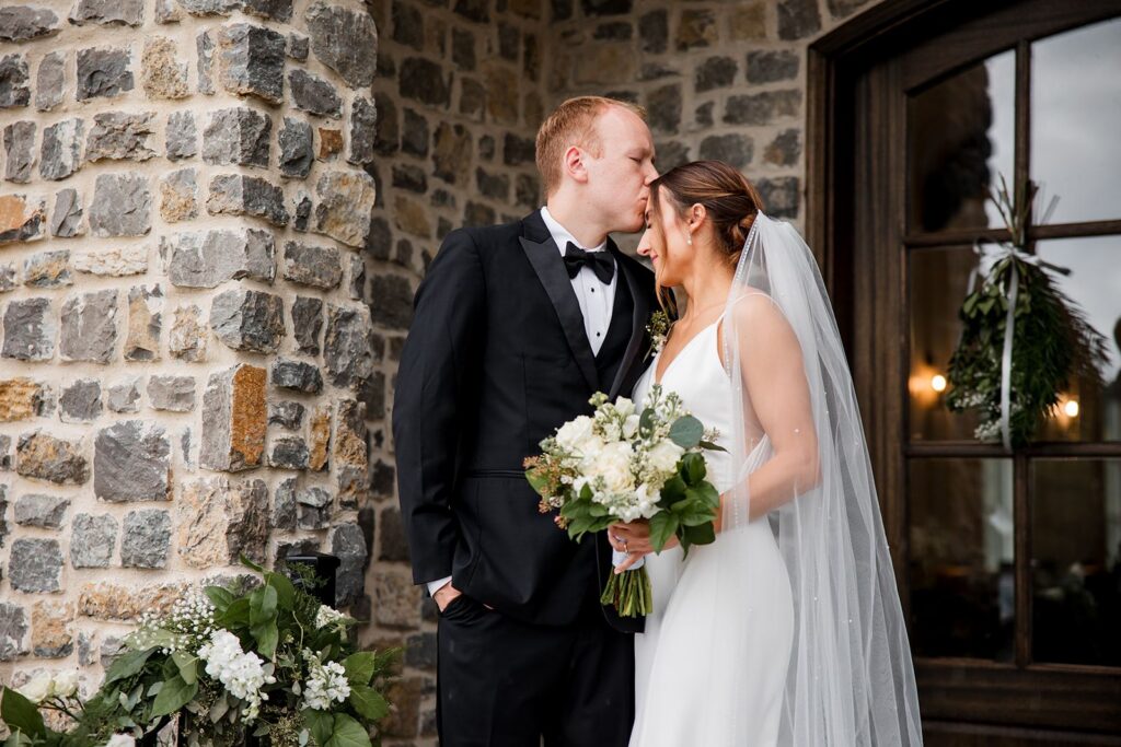 Groom kissing bride's forehead