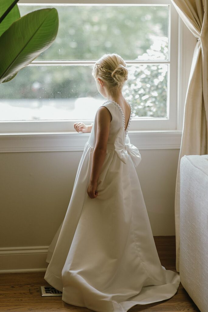 Inviting kids to your wedding flower girl gazing out the window