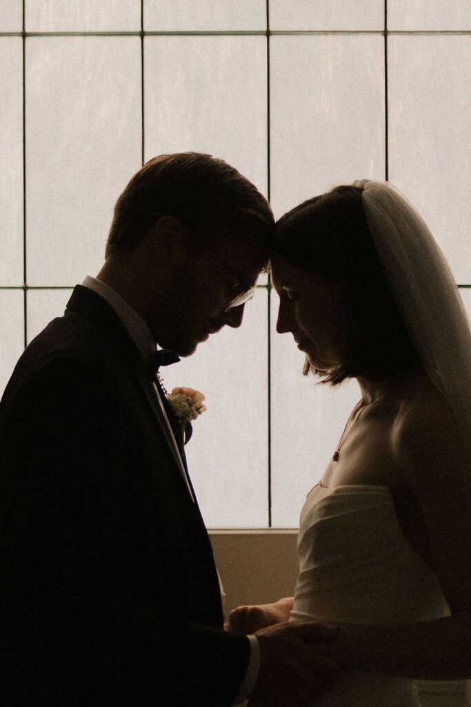 Bride and groom leaning foreheads together