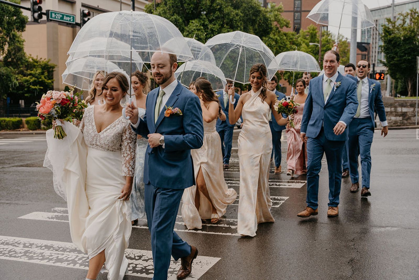Bride and groom and wedding party holding umbrellas