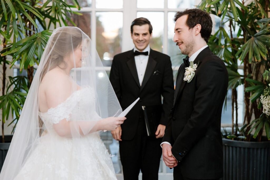 Bride reading wedding vows to groom during ceremony