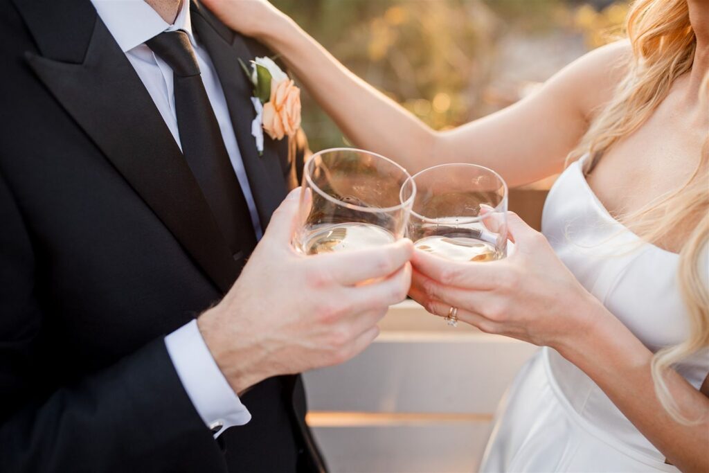 Bride and groom cheers with cocktails