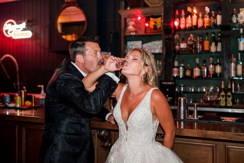 Bride and groom taking a shot in a bar