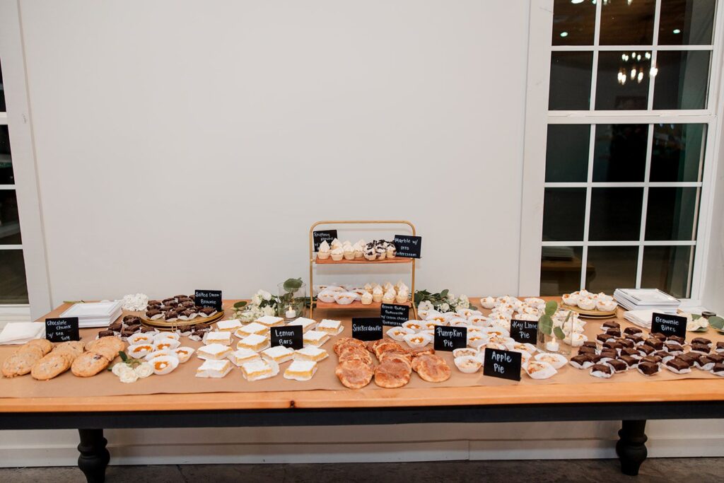 a wedding dessert display of brownies, pies, cakes, cupcakes, and other sweet treats