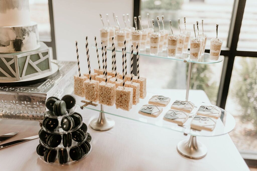 wedding dessert display of chocolate covered oreos, custom cookies, truffles, and rice krispy treats.