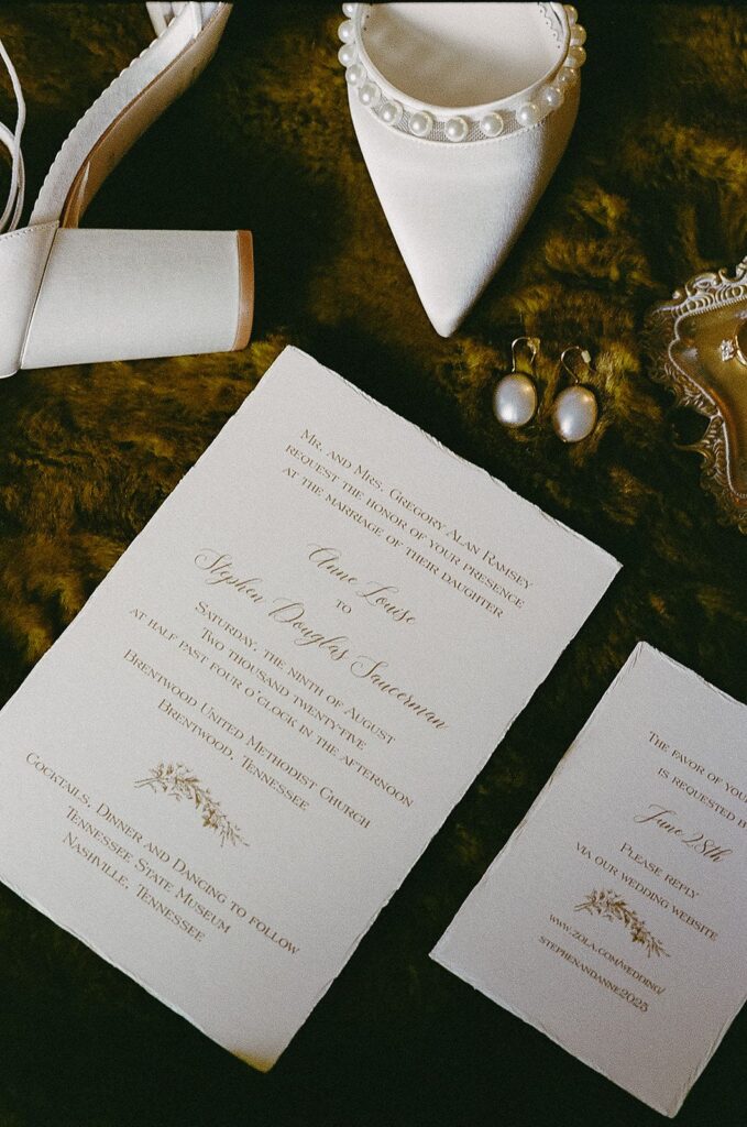 Wedding invitation spread with earrings and shoes
