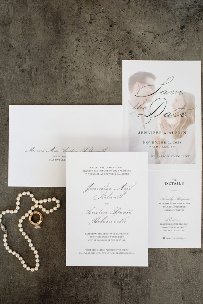 Guide to wedding invitation suite laid out with pearls