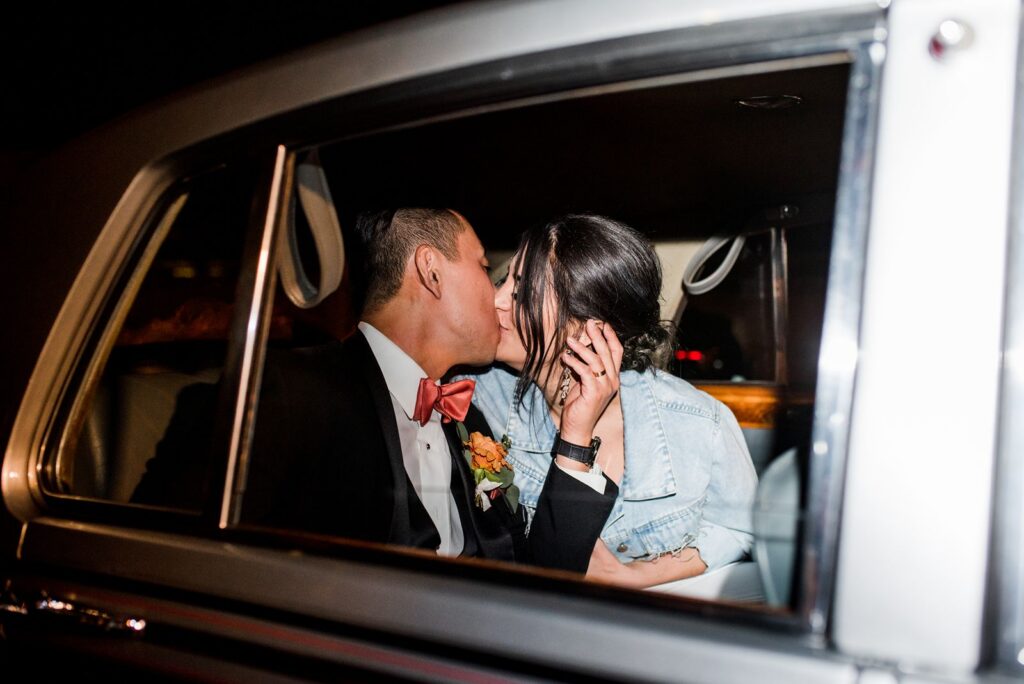 Wedding grand exit sendoff bride and groom kissing in vehicle