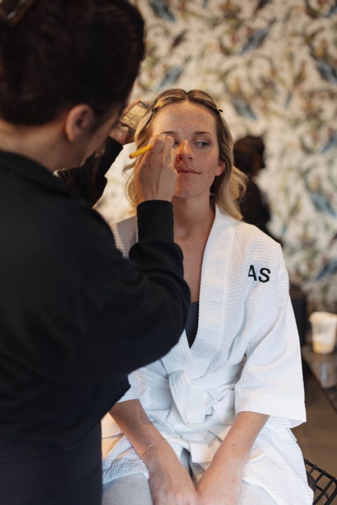 Bride getting her makeup done before wedding