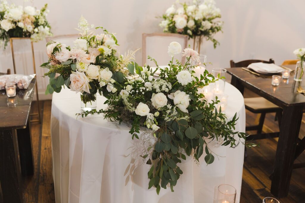 a sweetheart table set for a bride and groom with cascading flowers