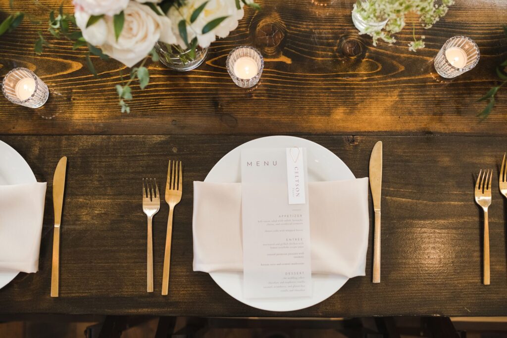 a dinner place setting with a menu for a wedding