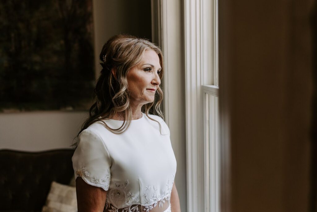 a bride looking at the window on her wedding day