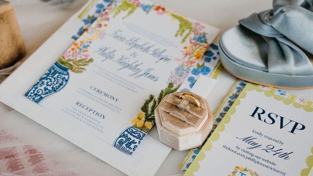 Wedding invitation card and RSVP card laid out with ring box